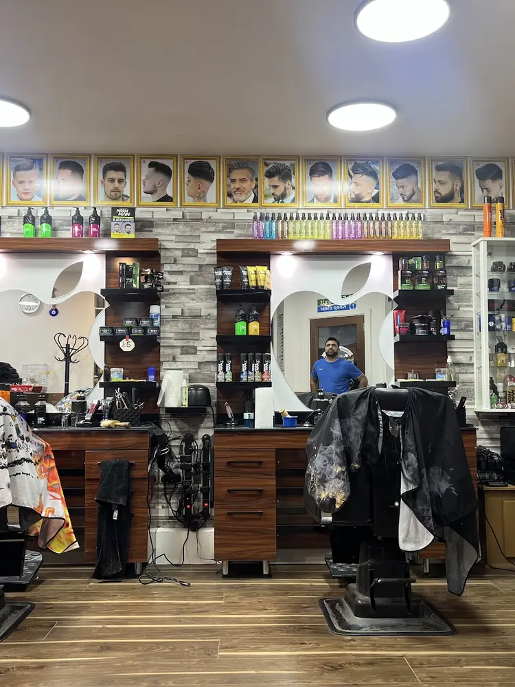 Interior of Efes Barbers with two barber chairs, mirrors and a row of framed haircut photos above