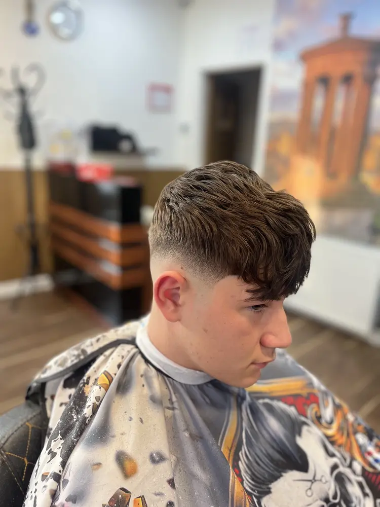 Close-up of a finished textured crop haircut with a clean low fade at the sides