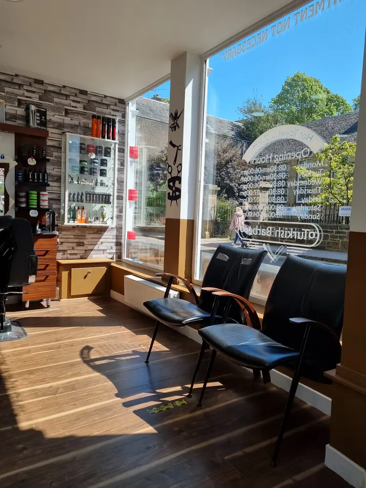 Sunlit waiting chairs beside the shop window at Efes Barbers